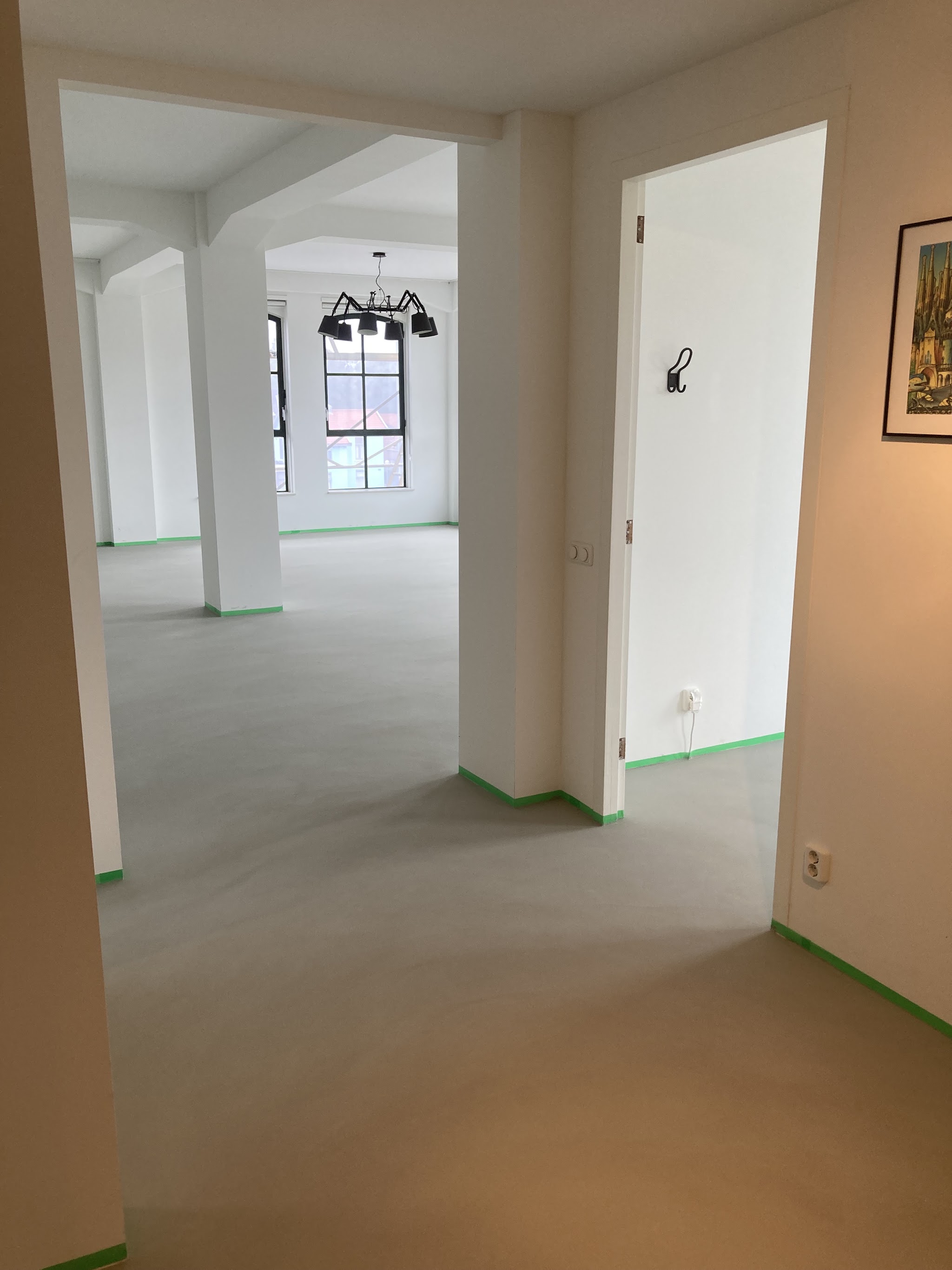 Doorkijk door een loft met witte wanden en een grijze vloer